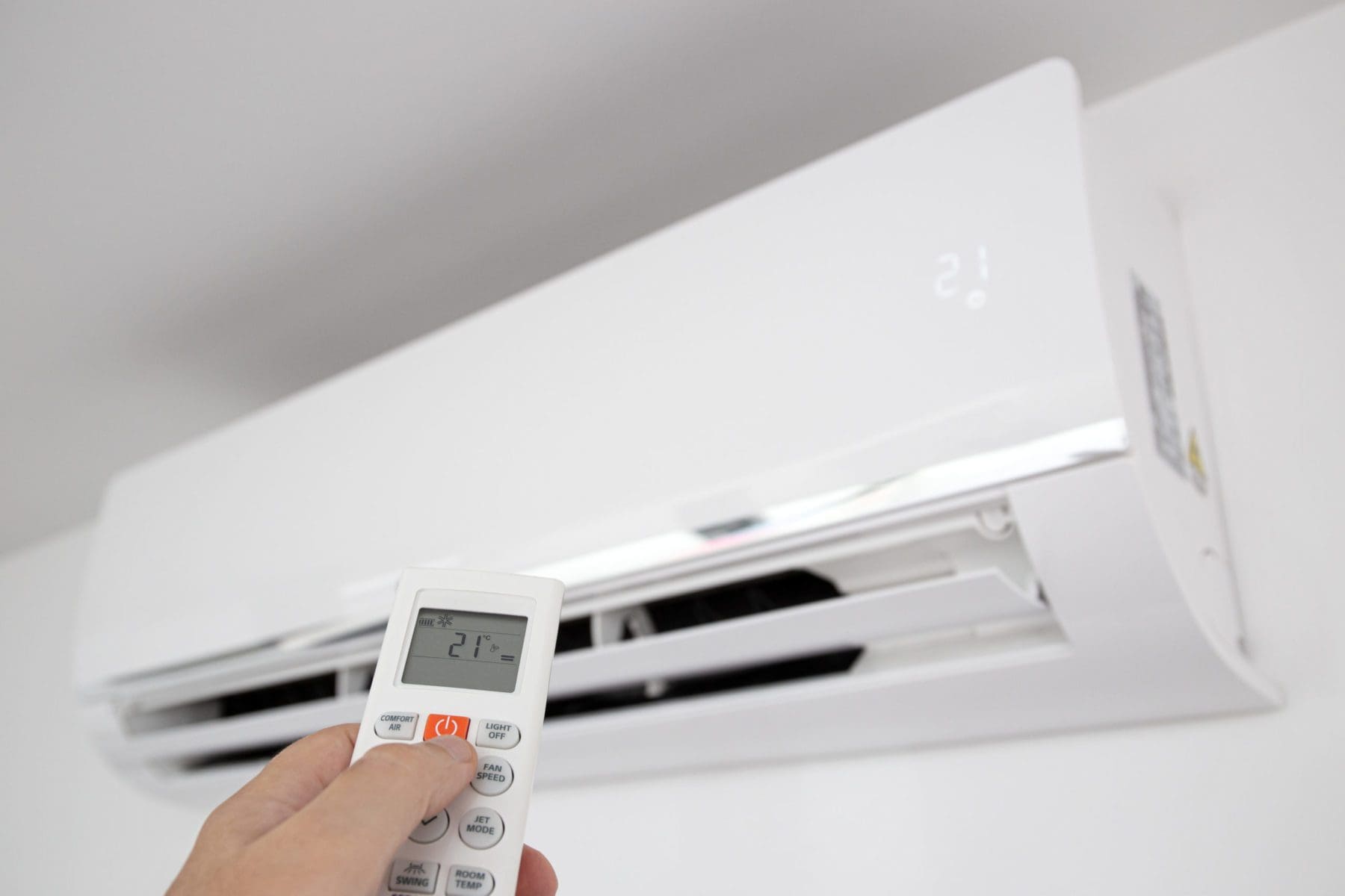 A Person operating a mini split air conditioning unit with a remote control - mini split installation service