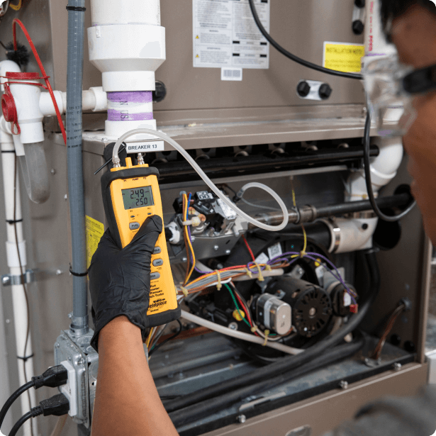 Technician checking on an HVAC system through a handheld tool